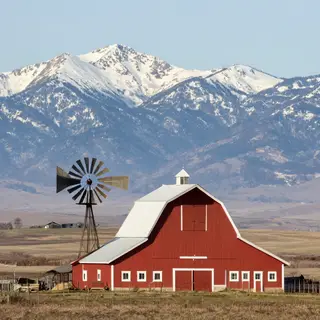 A landscape with a red barn in the foreground at large scale