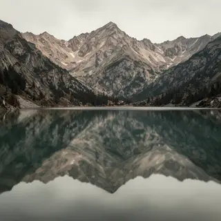 A mountain range reflected in a still alpine lake, with the 