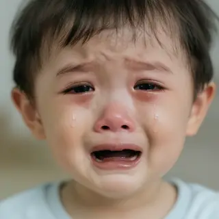 A 5-year-old child with round cheeks and large eyes, crying 