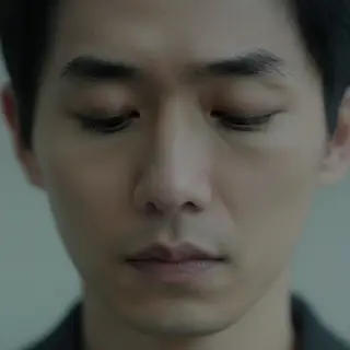A face showing quiet melancholy — downcast eyes, slightly dr