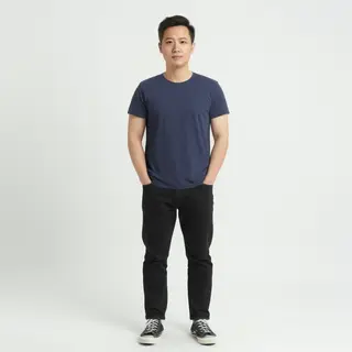 A man standing straight facing the camera, hands in pockets,
