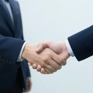 Two people shaking hands in a professional setting, all fing