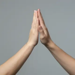 Two people doing a high-five, palms meeting with all fingers