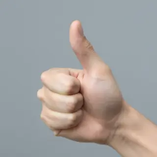 A hand giving a thumbs-up with four fingers curled and thumb