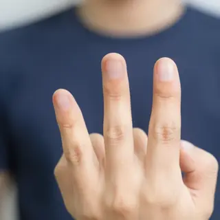 A person counting to three on their fingers, with index, mid