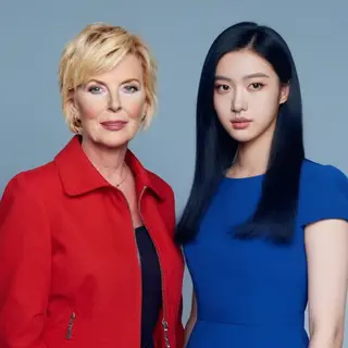 Two women standing side by side: one with short blonde hair 