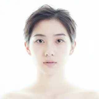 A high-key portrait of a person against a bright white backg