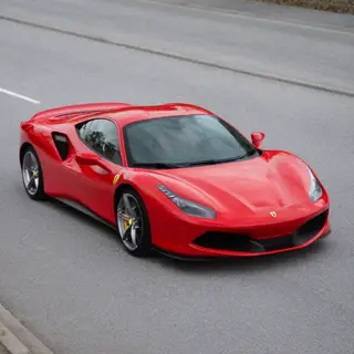 A bright red sports car parked on a gray asphalt road — the 