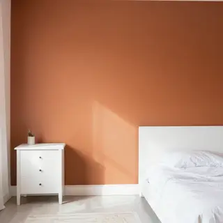 A bedroom wall painted in #FF6B35 (burnt orange) with white 