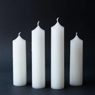 Exactly 4 white candles standing on a dark surface