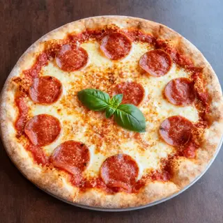 A pepperoni pizza with tomato sauce, basil, and crust but ab