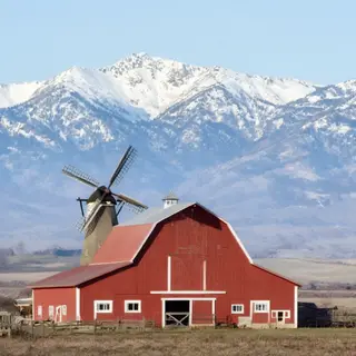 A landscape with a red barn in the foreground at large scale