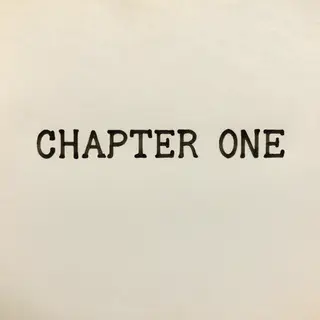 The word 'CHAPTER ONE' typed on aged paper with a vintage ty