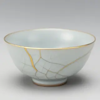 A Japanese kintsugi bowl — cracked ceramic repaired with vis