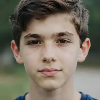 A headshot of a teenager with a relaxed, neutral face