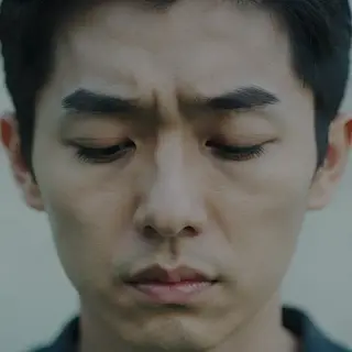 A face showing quiet melancholy — downcast eyes, slightly dr