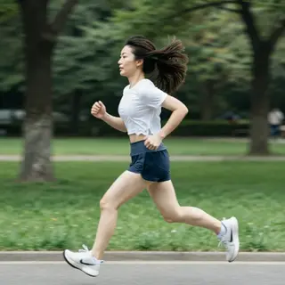 A woman mid-stride running through a park, hair and clothes 
