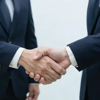 Two people shaking hands in a professional setting, all fing