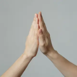 Two people doing a high-five, palms meeting with all fingers