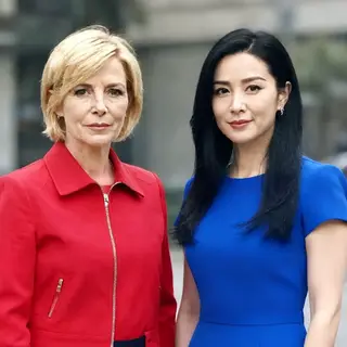 Two women standing side by side: one with short blonde hair 