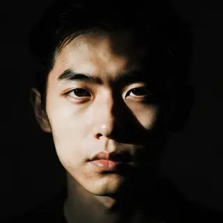 A portrait with dramatic split lighting — half the face brig