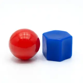 A red ball and a blue cube sitting side by side on a white s