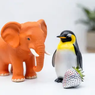 An orange elephant, a yellow penguin, and a silver strawberr