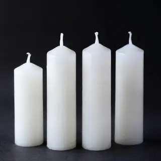 Exactly 4 white candles standing on a dark surface