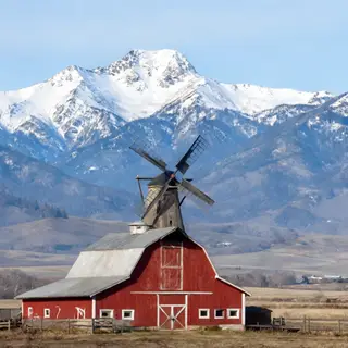 A landscape with a red barn in the foreground at large scale