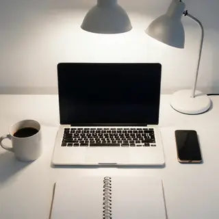 A desk scene: laptop in the center, coffee mug to the left, 