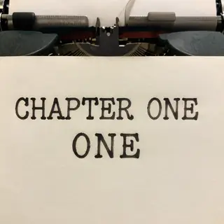 The word 'CHAPTER ONE' typed on aged paper with a vintage ty