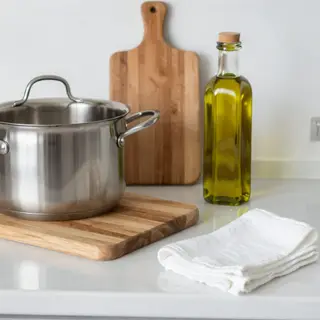 A kitchen counter with a stainless steel pot, a wooden cutti