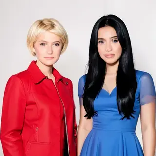 Two women standing side by side: one with short blonde hair 