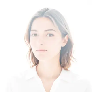 A high-key portrait of a person against a bright white backg