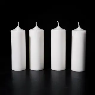 Exactly 4 white candles standing on a dark surface