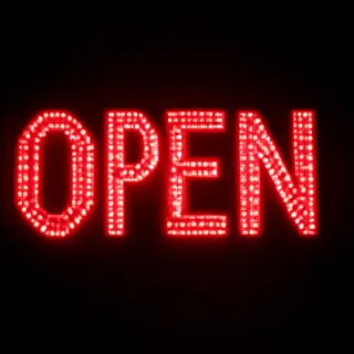 The word 'OPEN' displayed on a red LED sign with glowing pix