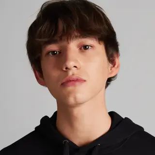A headshot of a teenager with a relaxed, neutral face