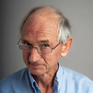 An elderly man in his 70s with age spots and thinning gray h