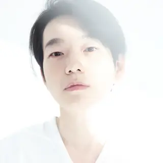 A high-key portrait of a person against a bright white backg