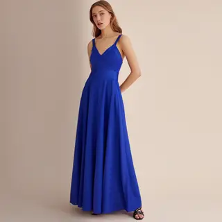 A woman wearing a royal blue evening dress against a neutral