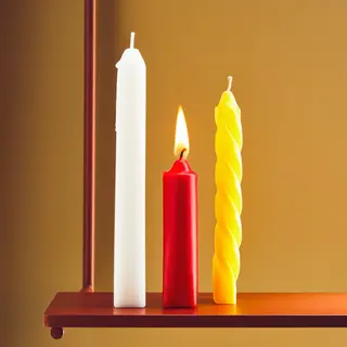 A tall thin white candle, a short fat red candle, and a medi