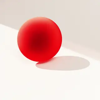 A red sphere on a white surface with a single shadow cast to