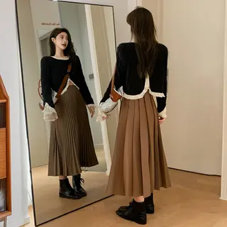 A woman standing in front of a full-length mirror, her refle