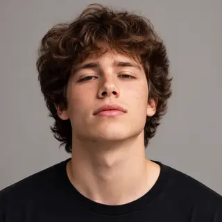 A headshot of a teenager with a relaxed, neutral face