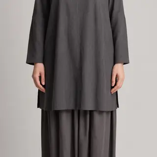 A person standing with both hands visible at their sides, fi