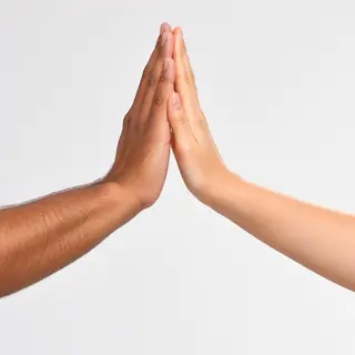 Two people doing a high-five, palms meeting with all fingers
