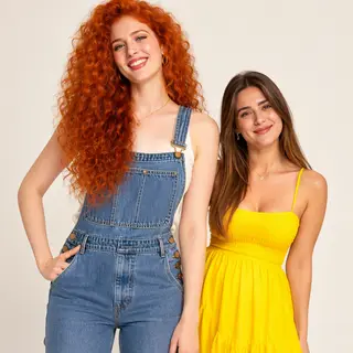 Two friends posing: one tall with curly red hair in denim ov