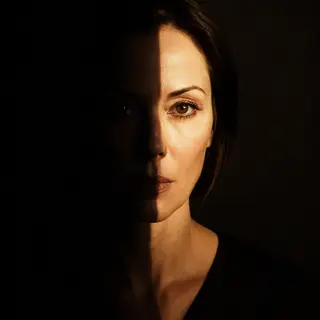 A portrait with dramatic split lighting — half the face brig