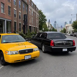 A yellow taxi and a black limousine parked next to each othe