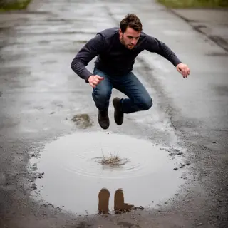 A man captured mid-jump over a puddle, body in the air with 